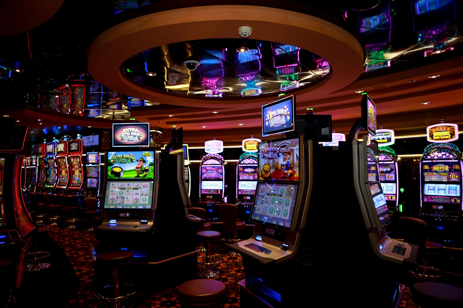 Række af oplyste spilleautomater på et casino